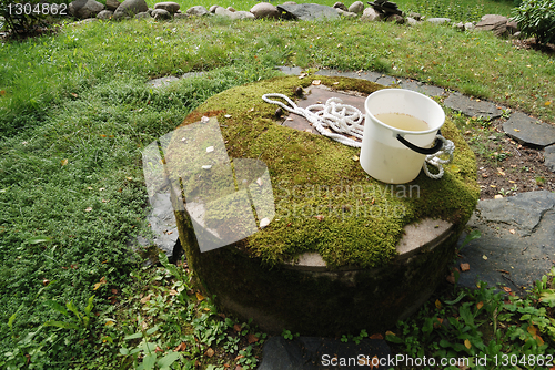 Image of typical concrete water well with moss