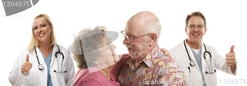 Image of Senior Couple with Medical Doctors or Nurses Behind