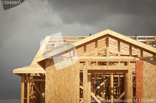 Image of Home Construction Framing with Ominous Clouds