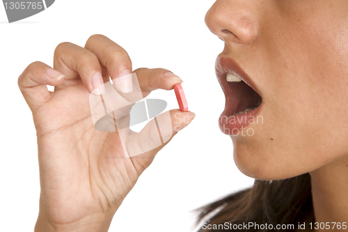 Image of young women pops a pill into her mouth