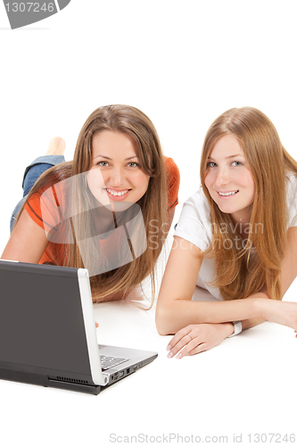 Image of two young happy student girl work on laptop