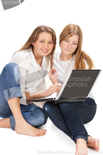 Image of two young happy student girl work on laptop