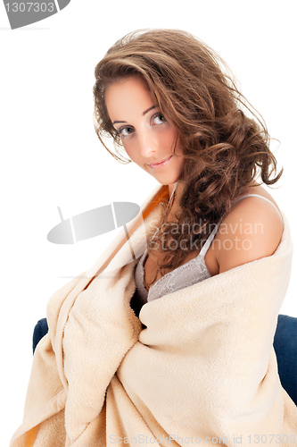 Image of young woman sitting on chair covered with blanket