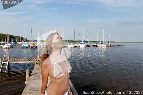 Image of Attractive young woman near the yachts