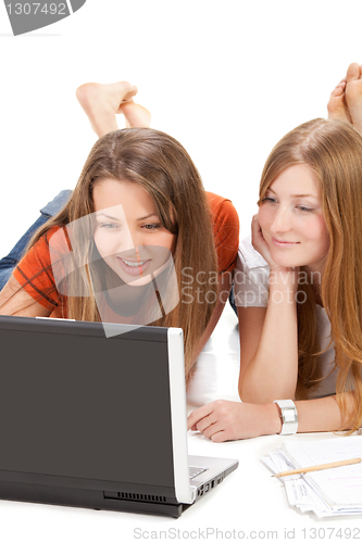 Image of two young happy student girl work on laptop