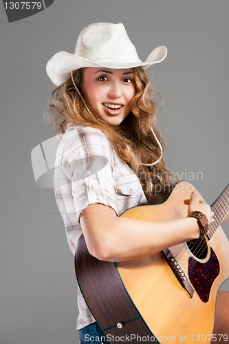 Image of Sesy cowgirl in cowboy hat with acoustic guitar