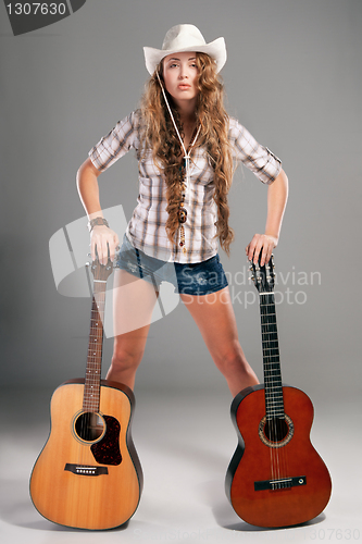 Image of Sesy cowgirl in cowboy hat with acoustic guitar