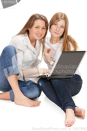 Image of two young happy student girl work on laptop