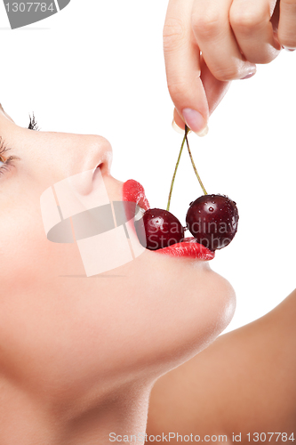 Image of young woman's mouth with red cherries