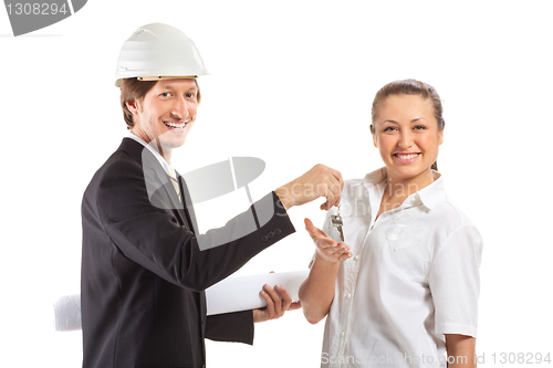 Image of smiling engineer giving keys from apartment