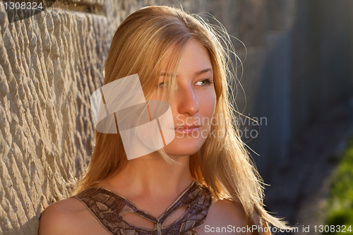 Image of Young woman outdoors at sunset