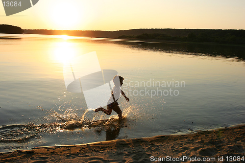 Image of running boy on the evening beach