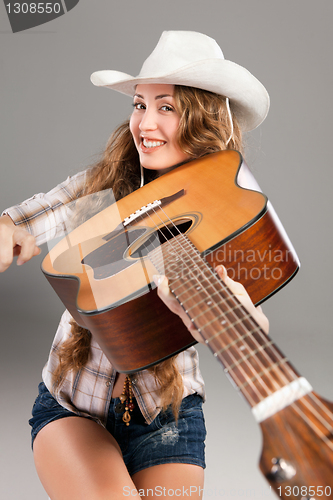 Image of Sesy cowgirl in cowboy hat with acoustic guitar