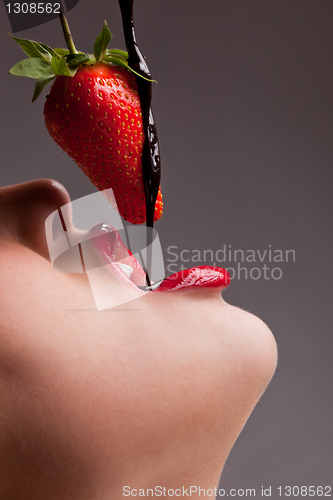 Image of girl eating strawberry with chocolate sauc