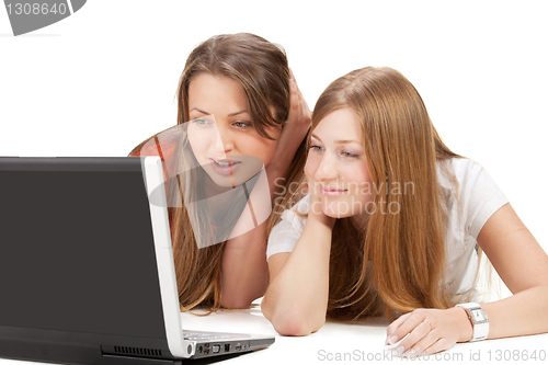 Image of two young happy student girl work on laptop