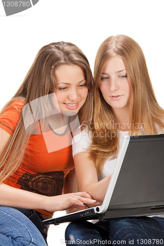 Image of two young happy student girl work on laptop