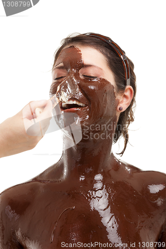 Image of young woman having a chocolate face mask