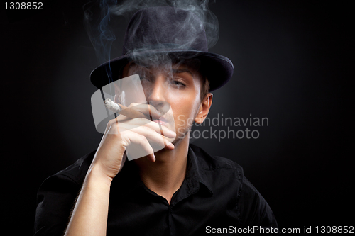 Image of Gangster look. Man with hat and cigar.