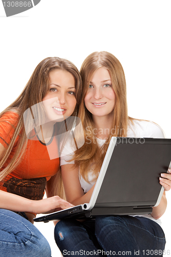 Image of two young happy student girl work on laptop