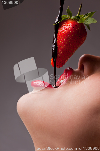 Image of girl eating strawberry with chocolate sauc