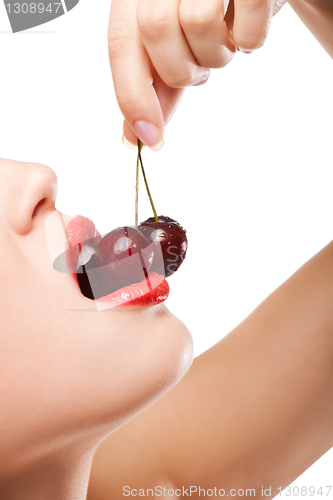 Image of young woman's mouth with red cherries