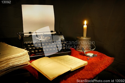 Image of old typewriter, old book and candle