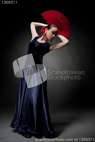 Image of young woman dancing flamenco on black