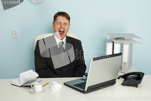 Image of Businessman yawning from boredom and idleness