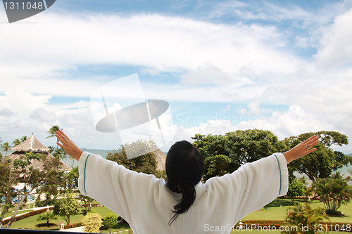 Image of women on the balcony taking a fresh air in background sea and is