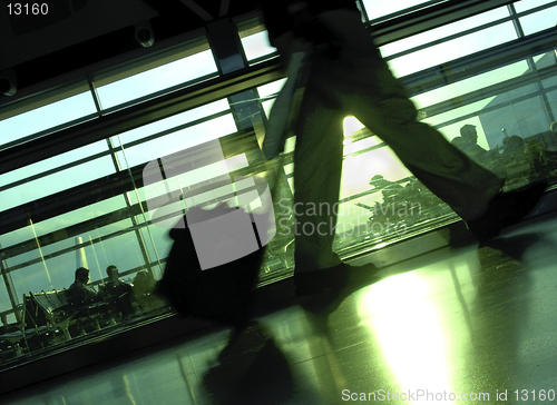 Image of Making the Flight, An airport terminal with silhouettes of passengers waiting and one man walking.