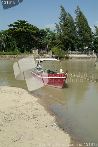 Image of Small, red motorboat at the beach