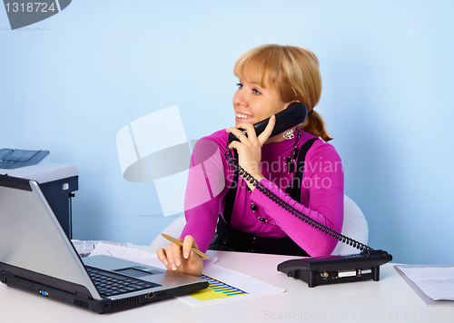 Image of Attractive girl secretary talking on phone