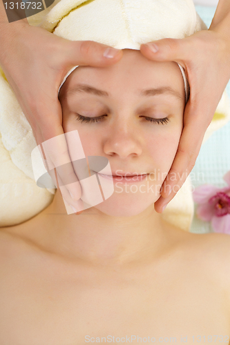 Image of Man's hands do woman's face massage