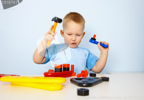 Image of Little boy playing with toy tool