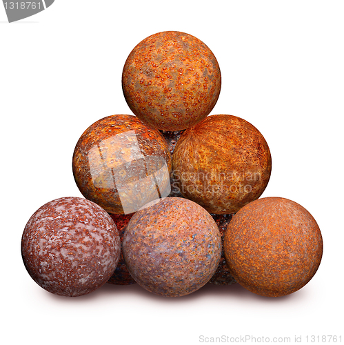 Image of Ten rusty iron cannon balls on white background
