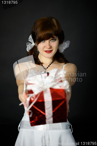 Image of Young attractive woman gives a gift in red box