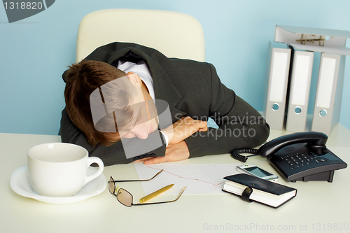 Image of Tired man sleeping on a table