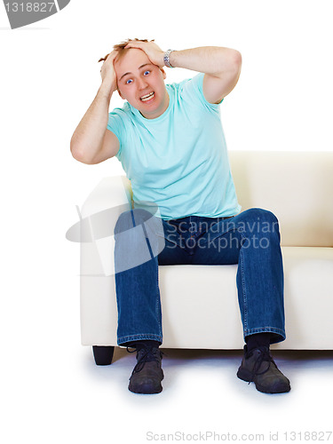 Image of Nervous hysteria man at home on sofa isolated on white