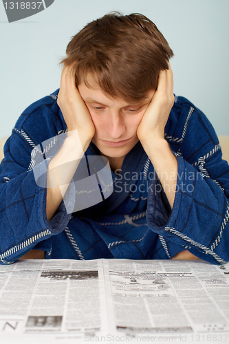 Image of Sad man reading a newspaper