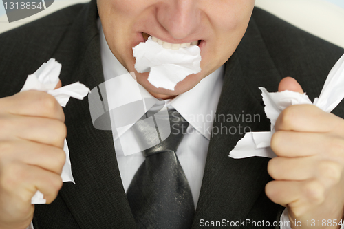 Image of Businessman furiously tearing paper