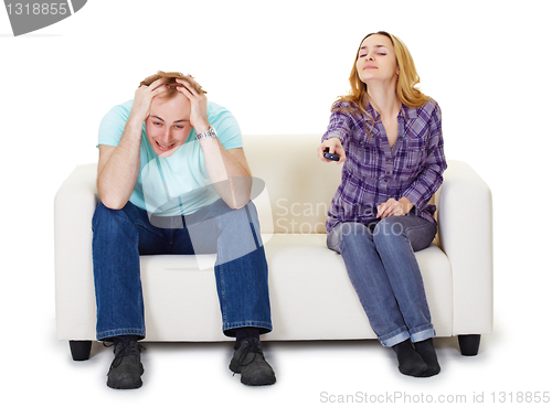 Image of Nervous husband and wife sitting on couch watching TV