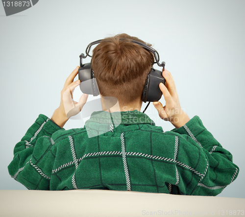 Image of Man listens to symphonic music at home on couch