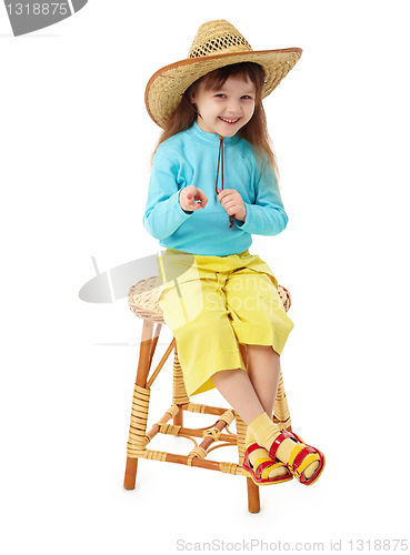 Image of Little girl in straw hat sitting on wooden chair