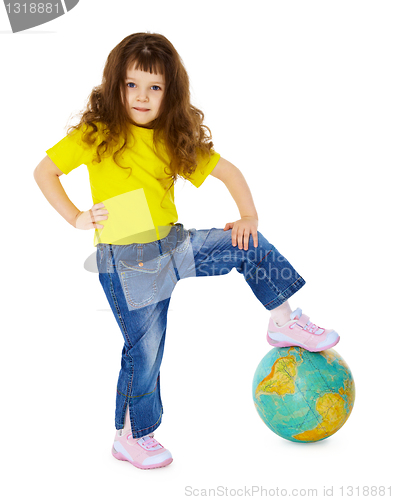 Image of Little girl put her foot on geographic globe