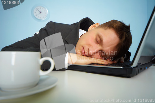 Image of Tired man sleeping on a notebook
