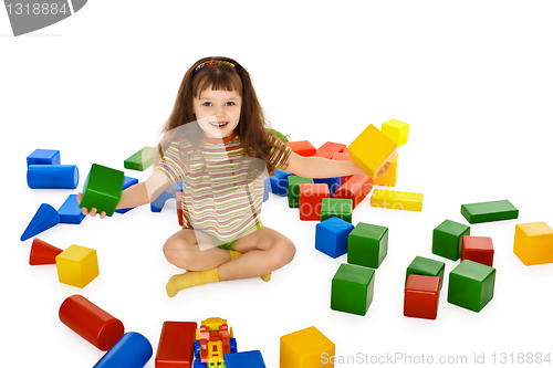 Image of Little girl playing with color cubes on floor