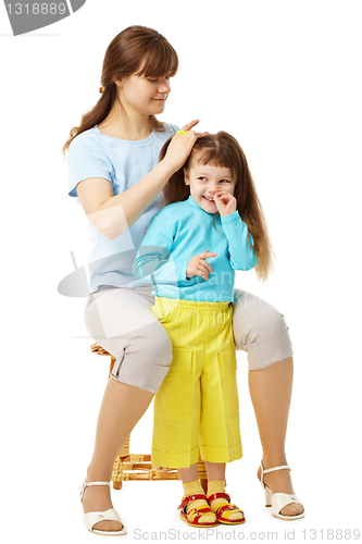 Image of Mom makes daughter hairstyle