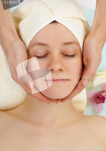 Image of Young woman doing facial in beauty salon