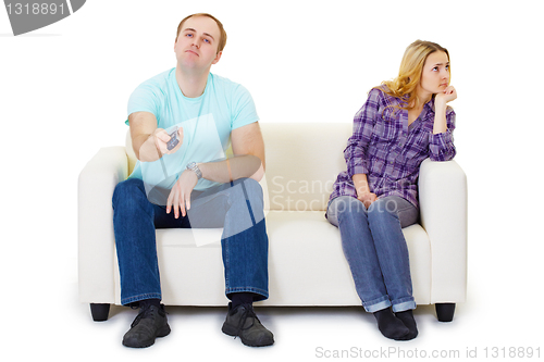 Image of Husband and wife in a quarrel sit on couch watching TV