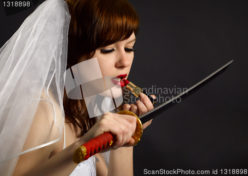 Image of Girl lipstick looking at blade of sword